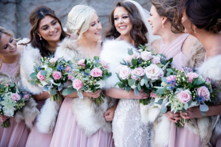 Bridal party with bouquets of pink flowers and greenery