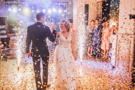 Bride and groom dancing at wedding under confetti 