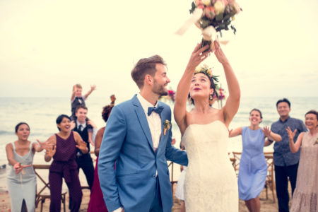 Wedding bouquet toss with bride and groom