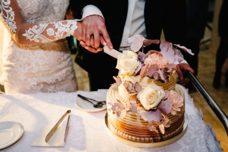 Bride and groom cutting small floral wedding cake