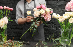Male florist as flower bar bartender arranging white and pink flowers