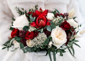 Bridal bouquet in bold colors with dark red amaryllis  and roses with white blooms