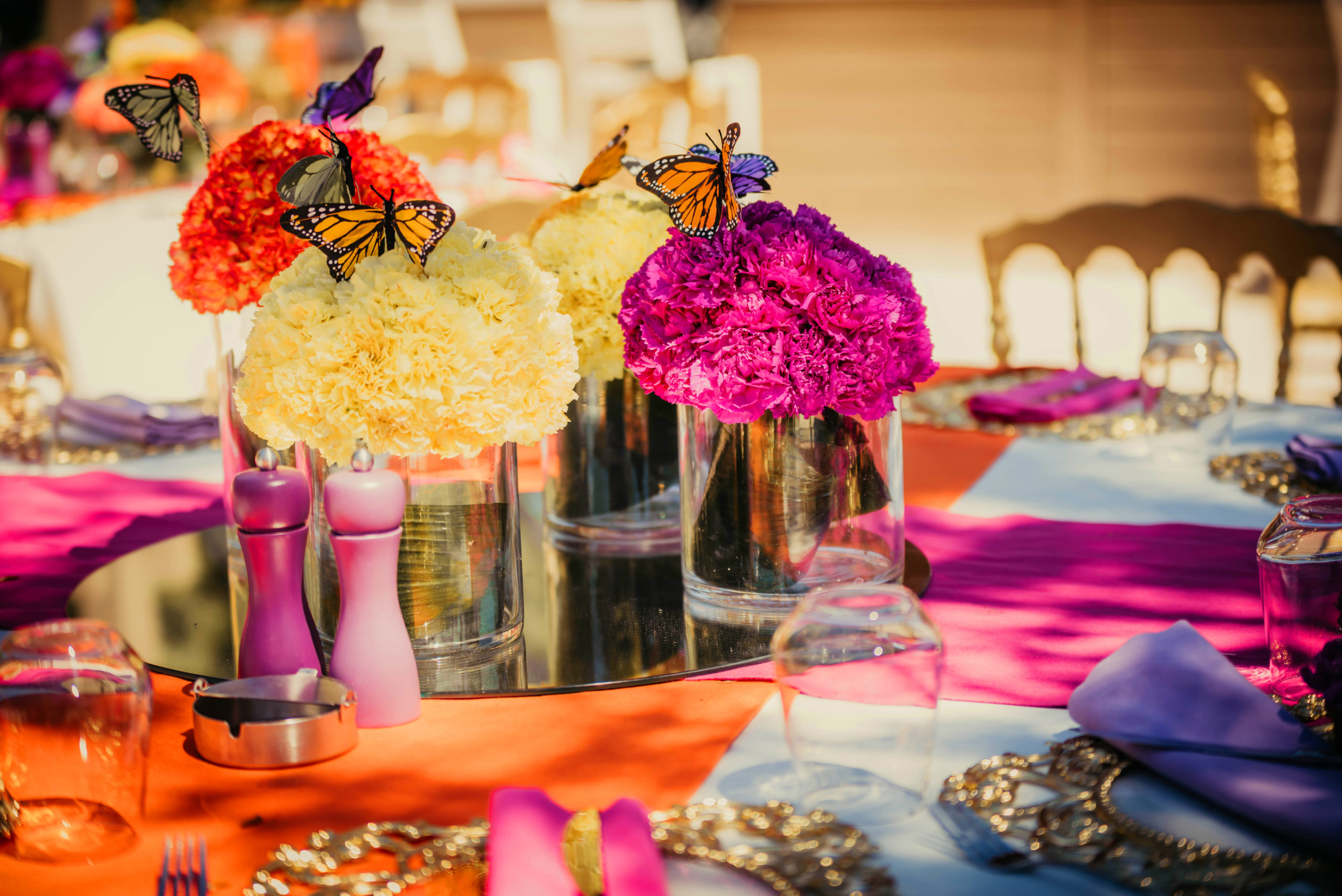 Colorful monochromatic floral arrangements with butterflies for special event