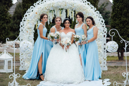 Bride with her friends in blue dresses with bouquets of flowers. Outgoing ceremony. Style. Fashion. Wedding.