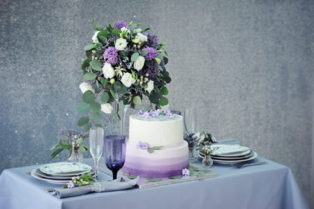Elegant wedding table setting in violet and gray at a luxury wedding reception, Flowers and wedding cake