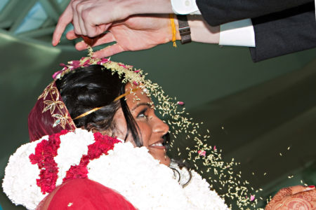 The bride and groom dump rice on each other during a traditional Hindu wedding ceremony