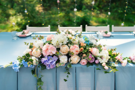 Wedding decor. Table for the newlyweds outdoor. Wedding reception. Elegant wedding table arrangement, floral decoration, restaurant. Wedding in the forest