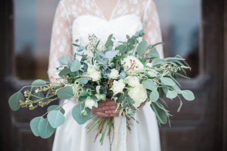 Handed wedding bouquet with roses and eucalyptus greenery.