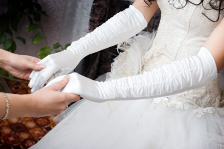 white gloves on the hands of the bride