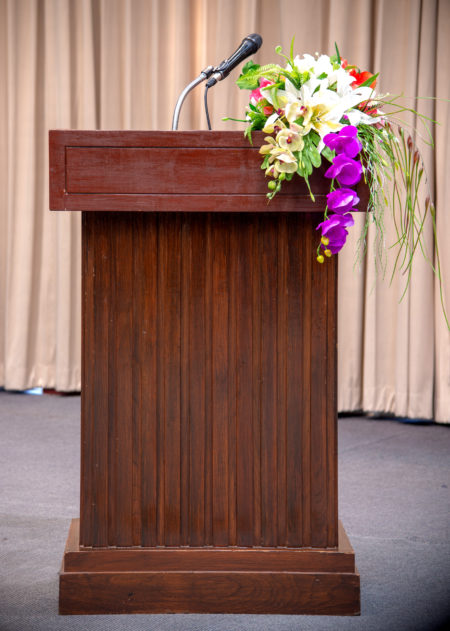 Microphone on stand podium decoration with colorful flower.