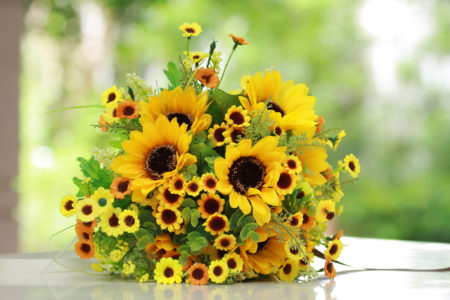 Luxury bouquet ,beautiful bouquet of bright yelloe flowers, plastics flower,on wooden table with nature green background.