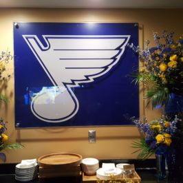 St. Louis Blues logo flanked by blue and yellow flowers