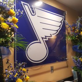 St. Louis Blues logo flanked by blue and yellow flowers