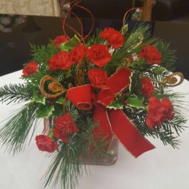 Holiday centerpiece of red flowers and winter greenery