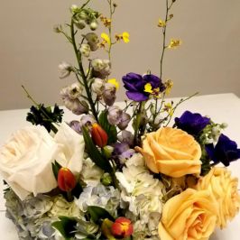 Centerpiece with orange, purple and white flowers