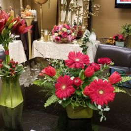 Centerpieces of red flowers and greenery