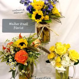 Variety of arrangements with bright yellow, orange and purple flowers