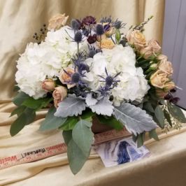 Arrangement of white, peach and blue flowers