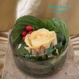 Centerpiece of a single rose and berries with greenery