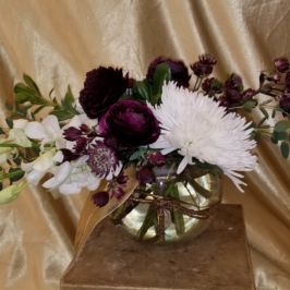 Centerpiece of white and purple flowers in a bowl vase