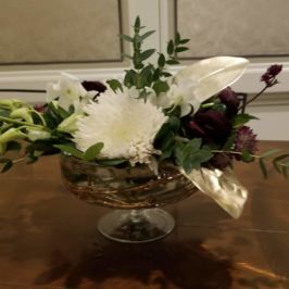 Centerpiece of white and burgundy flowers and greenery