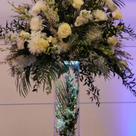 Tall centerpiece of white flowers and greenery