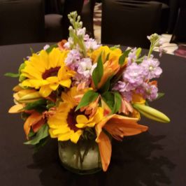 Centerpiece of orange, yellow and pink flowers