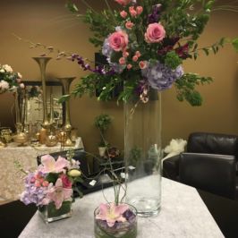 Centerpieces of pink and purple flowers of various heights