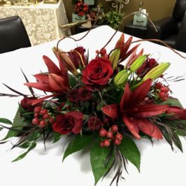 Centerpiece of red flowers and greenery